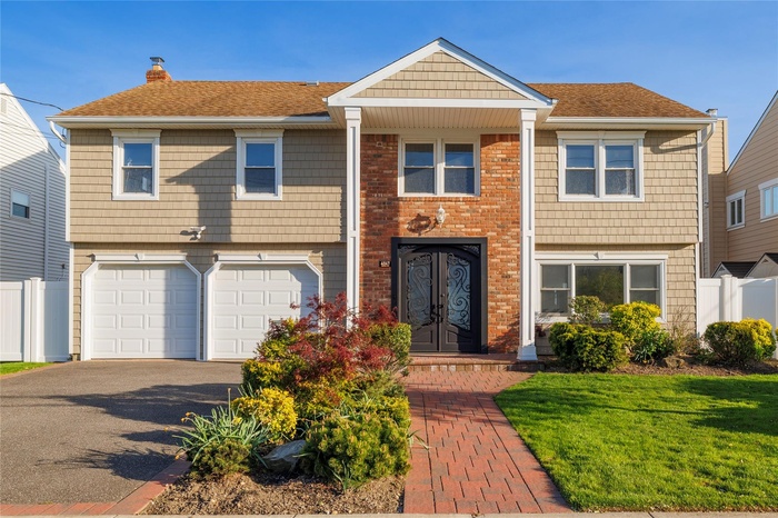 View of front of home featuring fence, aphalt driveway, a garage, a chimney, and french doors