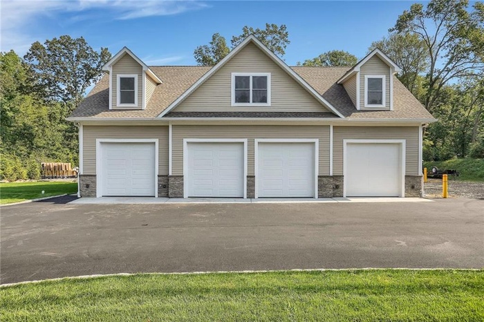 View of front of property with stone siding and a shingled roof