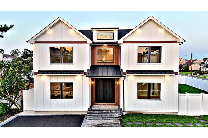 Modern farmhouse featuring a metal roof, a standing seam roof, and board and batten siding