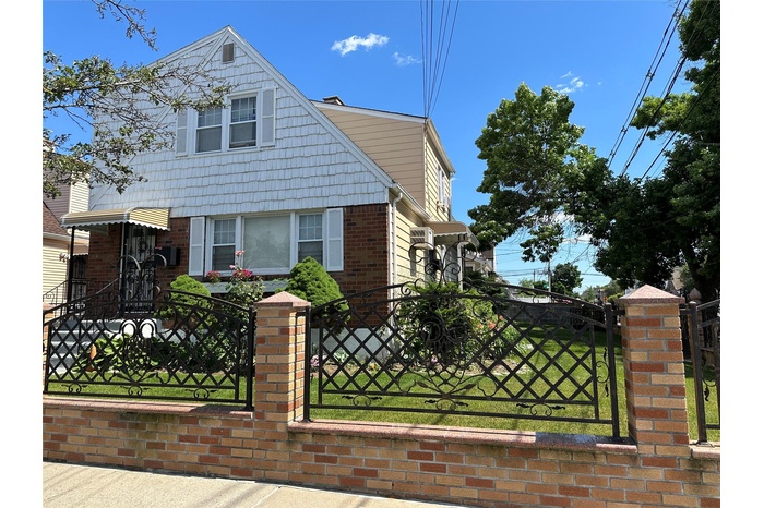 View of front facade with a fenced front yard and brick siding
