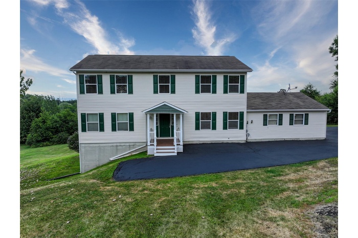 Colonial home with a patio area, a front lawn, and asphalt driveway