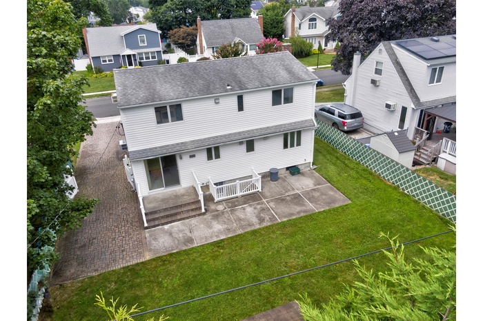Back of property with a patio, roof with shingles, a residential view, and a fenced backyard