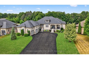 Step into this impressive raised bungalow in Wasaga Beach's prestigious Wasaga Sands Estates, set on a rare ravine lot surrounded by expansive estate properties.