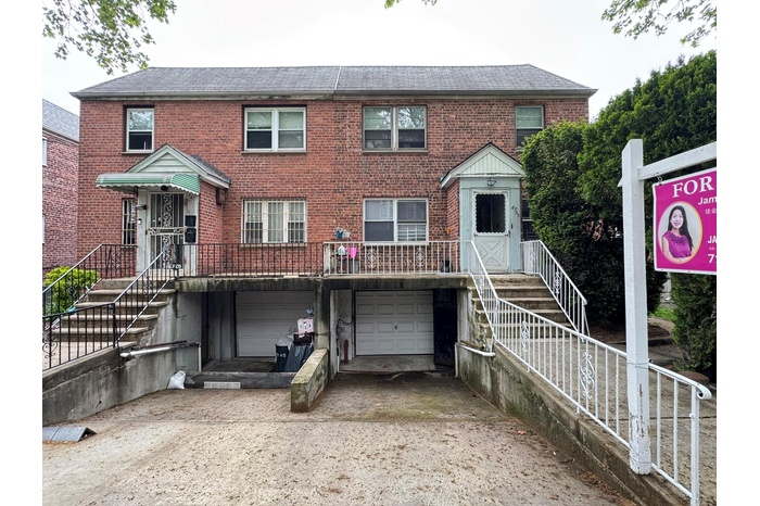Multi unit property with driveway, roof with shingles, brick siding, and an attached garage