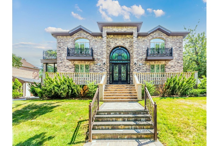 French country home with french doors, a balcony, brick siding, and a front yard