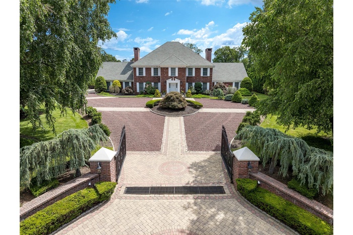 Iconic Georgian Colonial in the Murray Hill Estate Section in Scarsdale features circular 3-tone driveway, classic details, two chimneys, brick siding