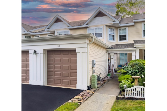 View of front of home with a garage and driveway