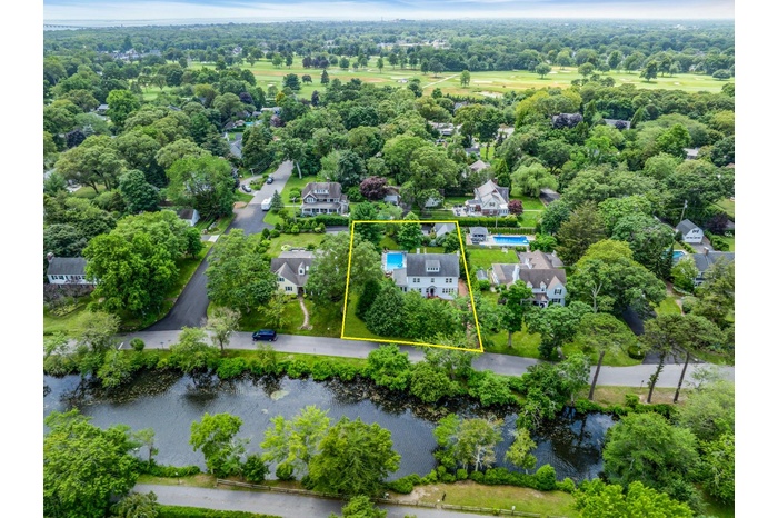Aerial view of property and surrounding area featuring a nearby body of water and property boundaries highlighted