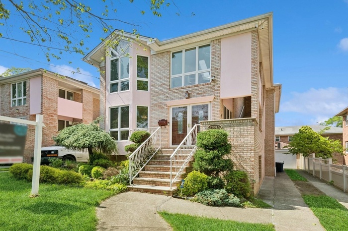 View of front of house featuring brick siding and stucco siding