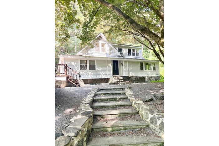 View of front of house featuring covered porch and stairway