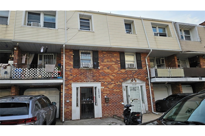 View of front of property featuring an attached garage and brick siding