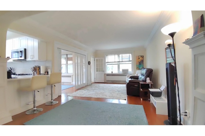 Living area with radiator, crown molding, and wood finished floors