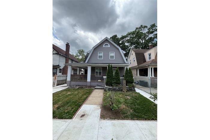 Colonial inspired home featuring a gambrel roof and a porch