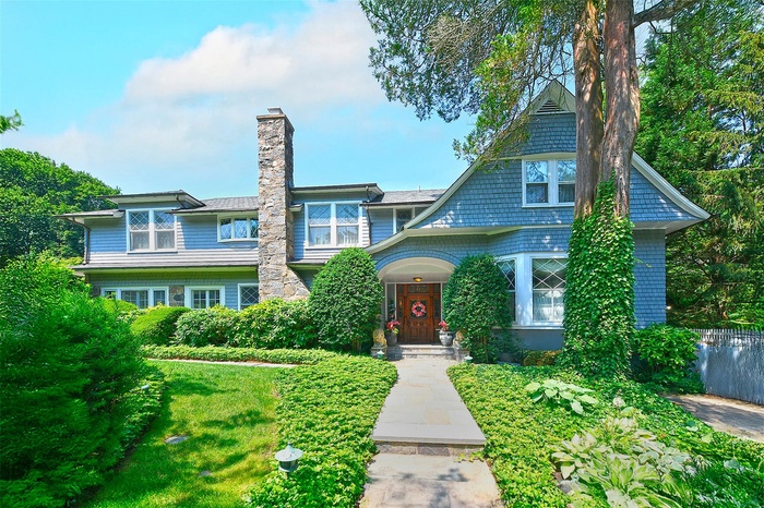 View of front of house with a chimney and a front yard