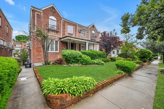 View of front facade with brick siding and a front yard