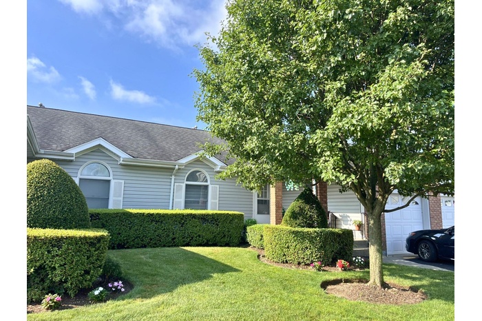 Obstructed view of property featuring a front lawn and a shingled roof