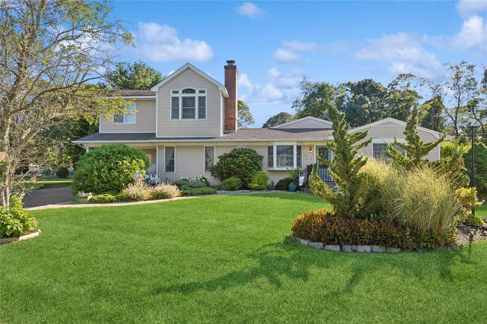 View of front facade with a chimney and a front lawn