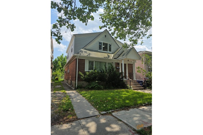 View of front of home featuring brick siding and a front lawn
