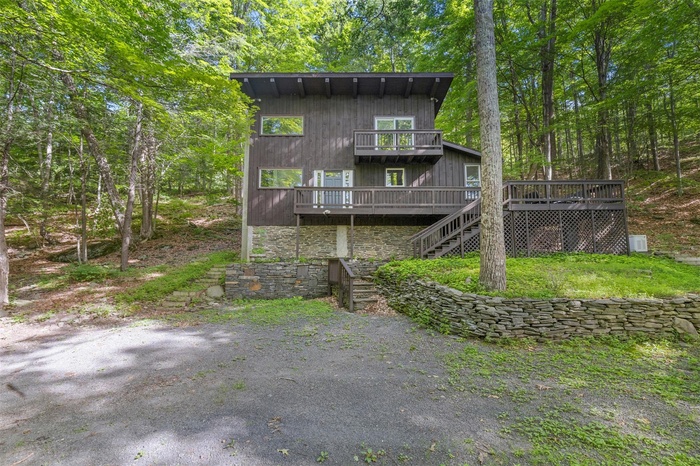 Back of property with a deck and stairway
