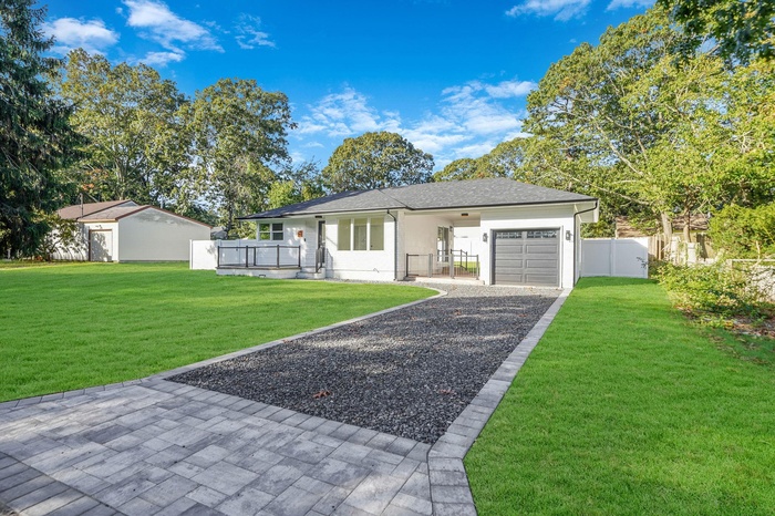 Single story home featuring an attached garage and gravel driveway