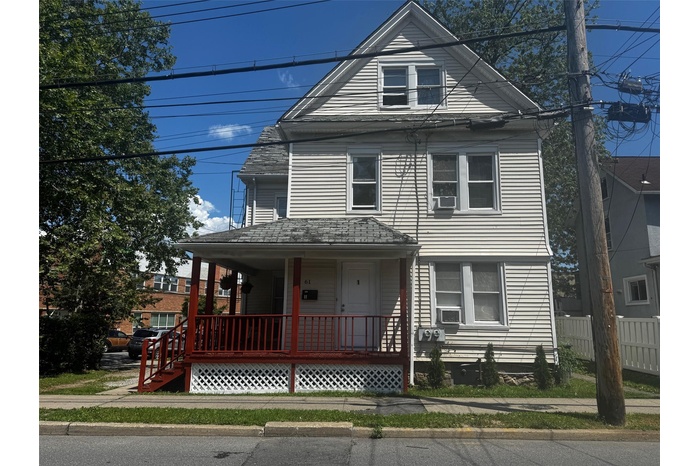View of front of property featuring covered porch and cooling unit