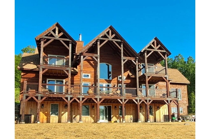 Rear view of property featuring a balcony, board and batten siding, and a shingled roof