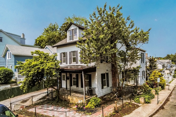 View of front of house with a porch, roof with shingles, and a residential view