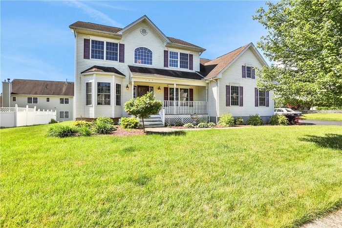 Colonial-style house with a front yard and a porch