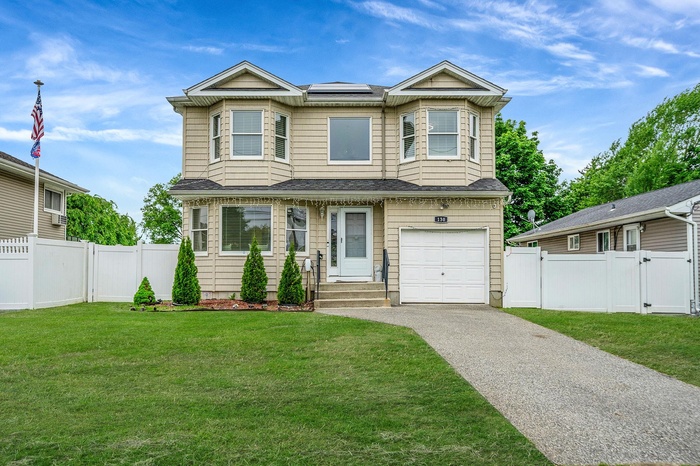 Townhome / multi-family property featuring a gate, driveway, a garage, and a shingled roof