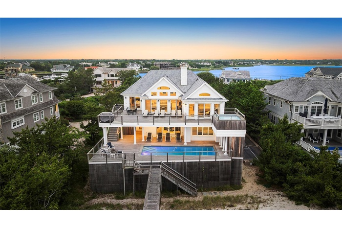 Rear view of house with stairs, a balcony, a chimney, an outdoor pool, and a patio