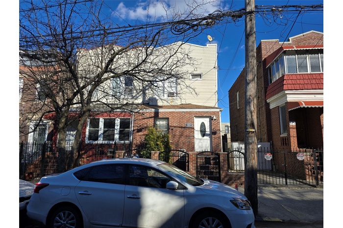 Multi unit property featuring a gate, brick siding, and a fenced front yard