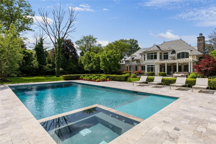 View of swimming pool featuring a pergola, a patio, a pool with connected hot tub, and a yard