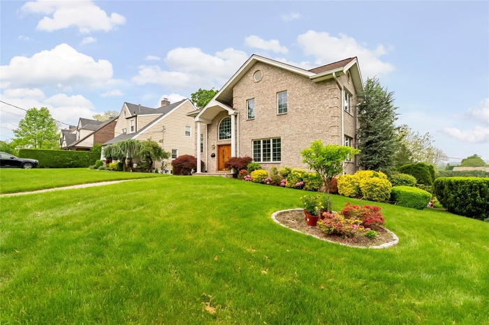 Traditional-style home featuring brick siding and a front yard