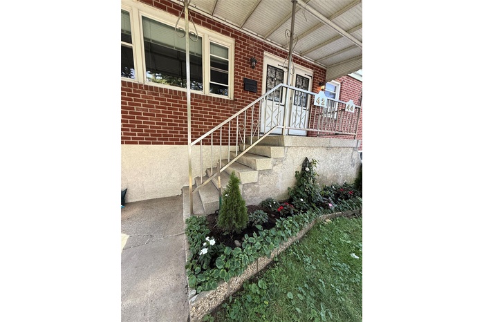 Entrance to property featuring brick siding and a porch