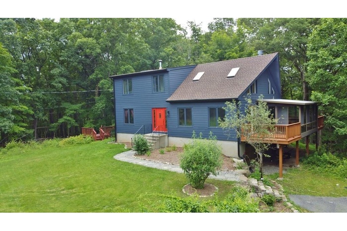 Rear view of property with a lawn, a shingled roof, and a wooden deck