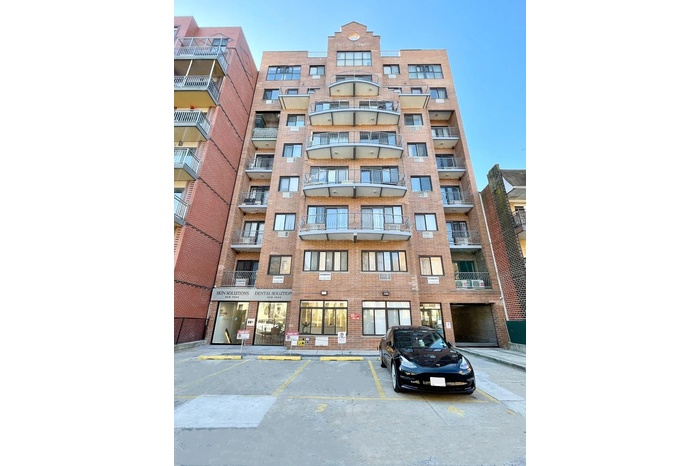 View of apartment building / complex with uncovered parking