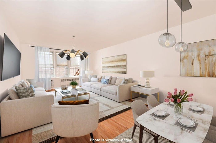 Living room with radiator heating unit, wood finished floors, and a chandelier