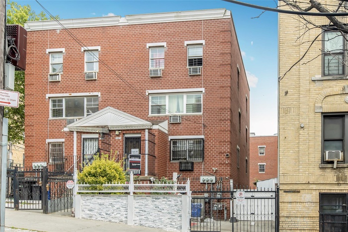 Multi unit property featuring brick siding, a gate, cooling unit, and a fenced front yard