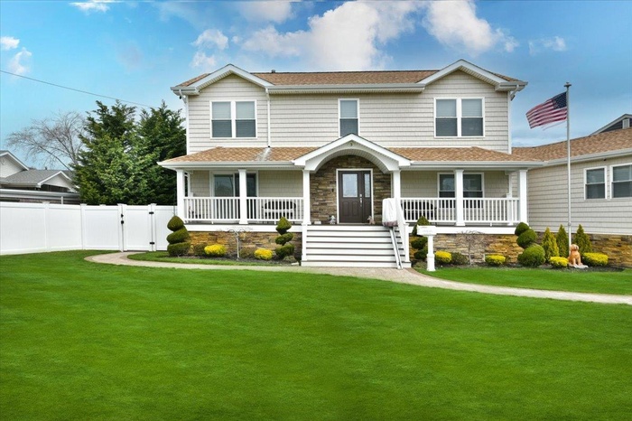 View of front of house featuring covered porch, a gate, and roof with shingles