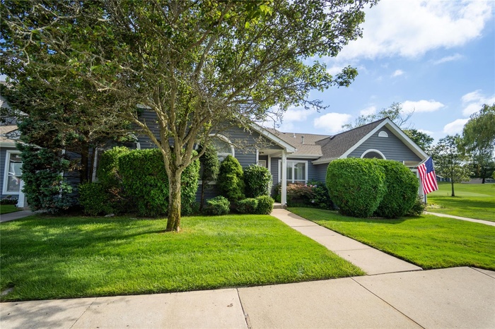 View of front of property with a front yard and a shingled roof