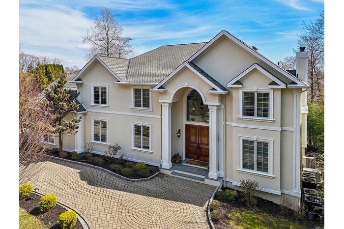 Traditional home featuring stucco siding and a chimney