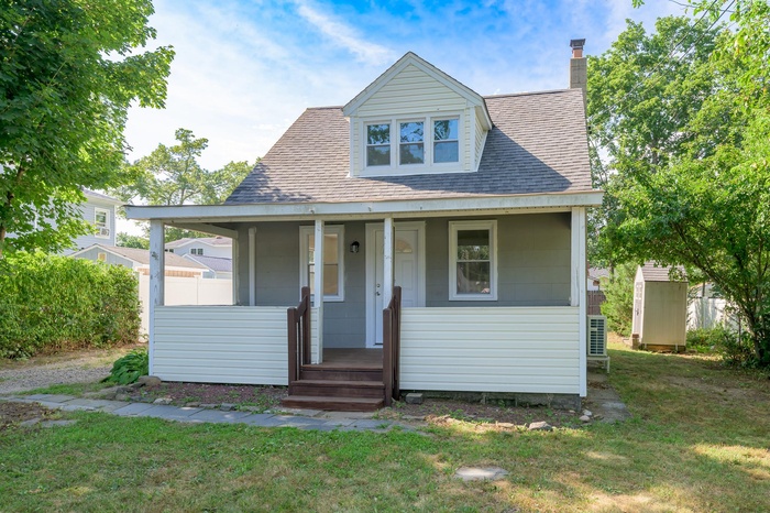 Bungalow-style home featuring covered porch on a nice-sized property. Long driveway.