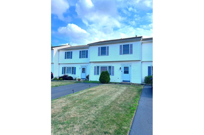 Townhouse featuring a front lawn