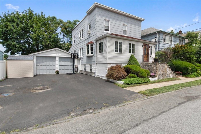 View of side of home featuring an outdoor structure and a detached garage