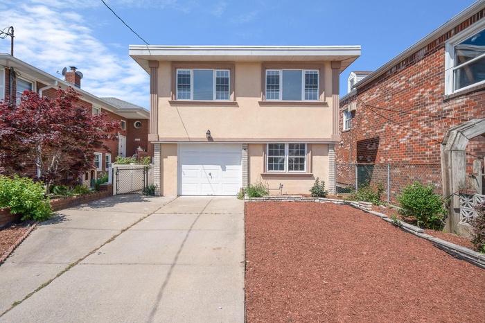 View of front of house featuring stucco siding, concrete driveway, fence, and a garage