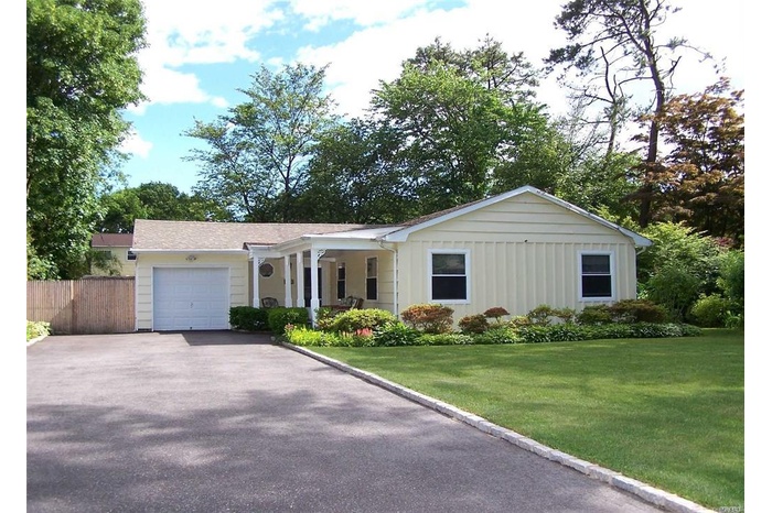 Single story home featuring an attached garage, asphalt driveway, and board and batten siding