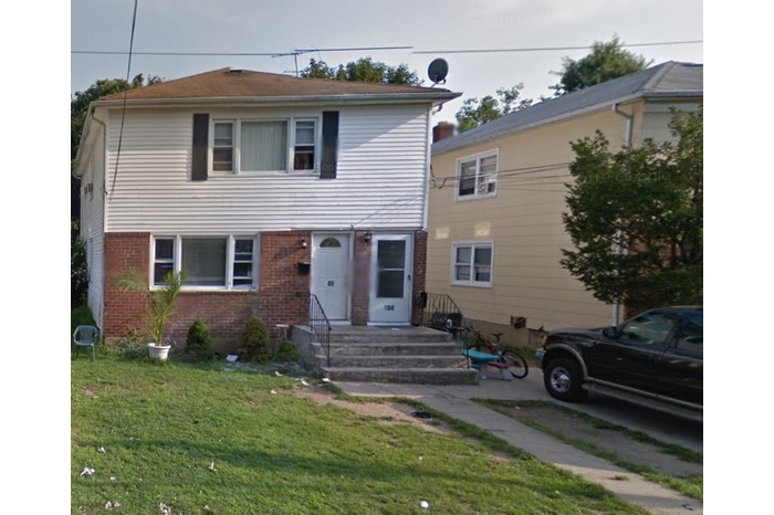 View of front of property with brick siding and a front lawn