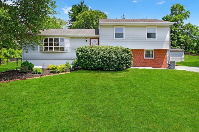 Rear view of property featuring brick siding and roof with shingles
