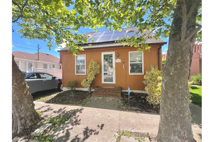 Bungalow with roof mounted solar panels and roof with shingles