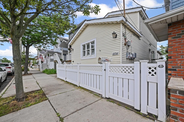 View of home's exterior featuring a fenced front yard and a gate